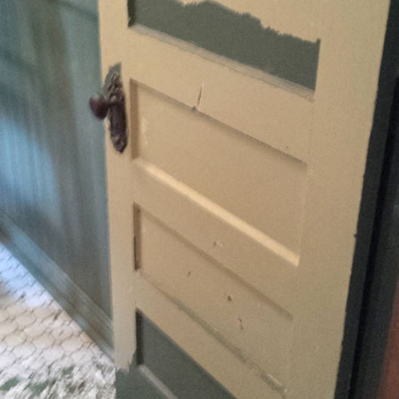 Scraping and more scraping of failing paint on the bathroom door